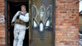 UKRAINE – Ukrainian military forces' serviceman stands on the doorstep of a house in Mariinka, on the front line with Russian hybrid forces, Donetsk region, on February 7, 2022