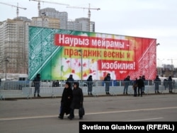 Люди проходят мимо площади, огражденной полицейскими. Астана, 22 марта 2013 года.